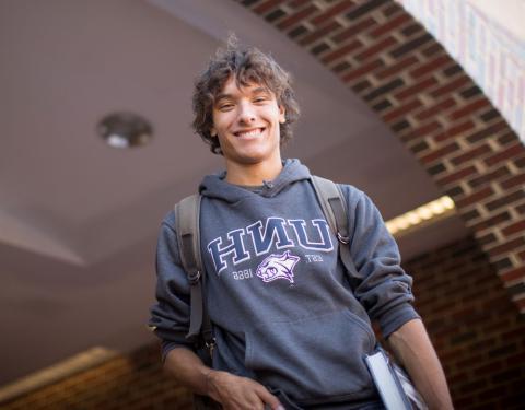 Male UNH Undergraduate Student smiling and wearing a backpack 