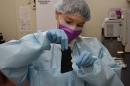 Lab worker swabs a gun grip